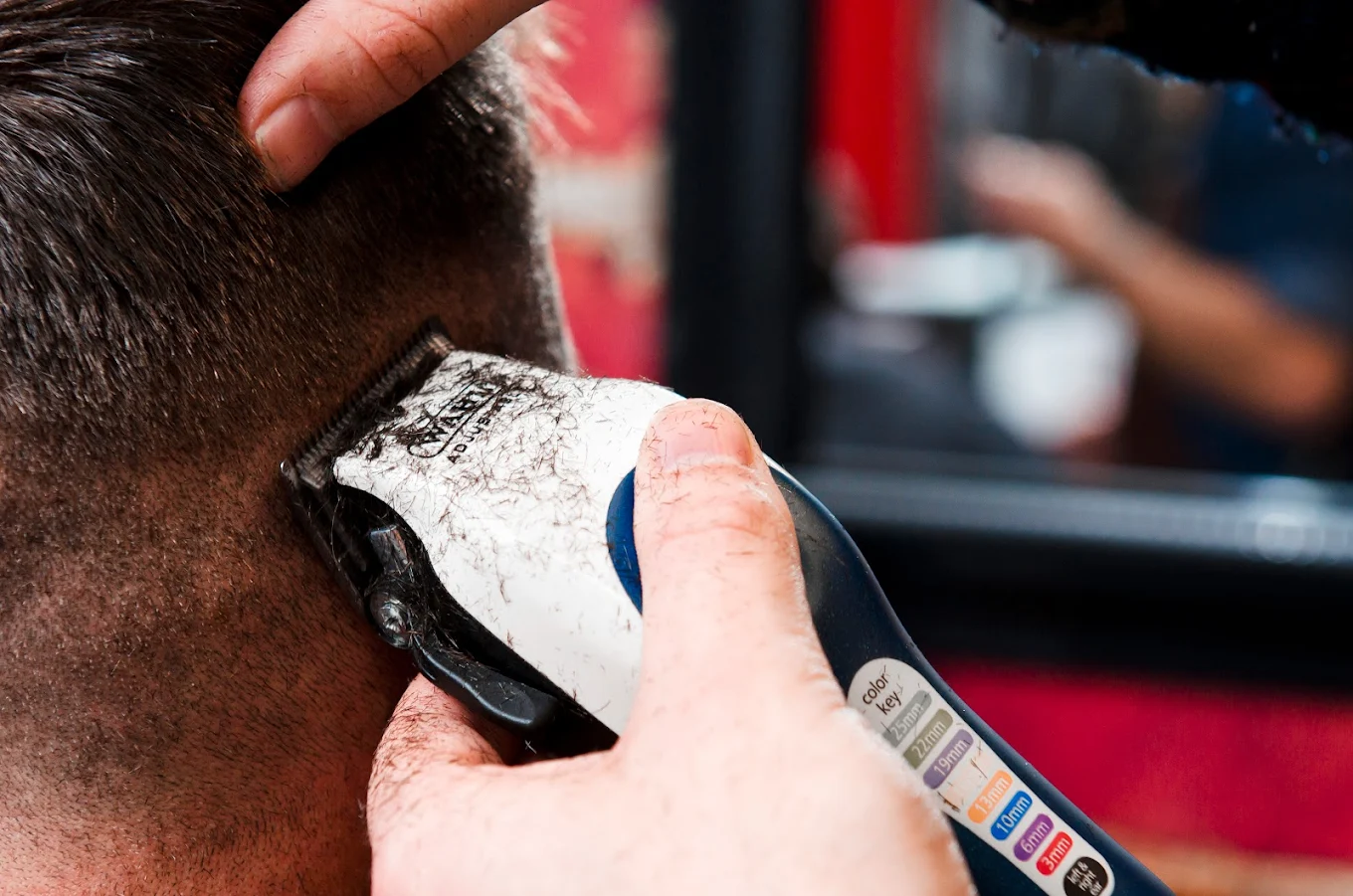 Barber giving a precision skin fade with clippers